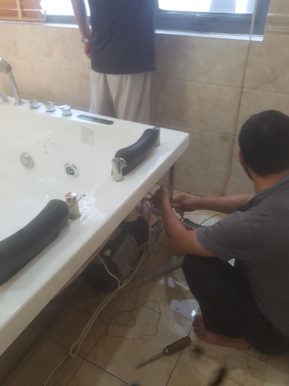 Hình ảnh nhân viên của Trung tâm đang sửa chữa bồn tắm massage