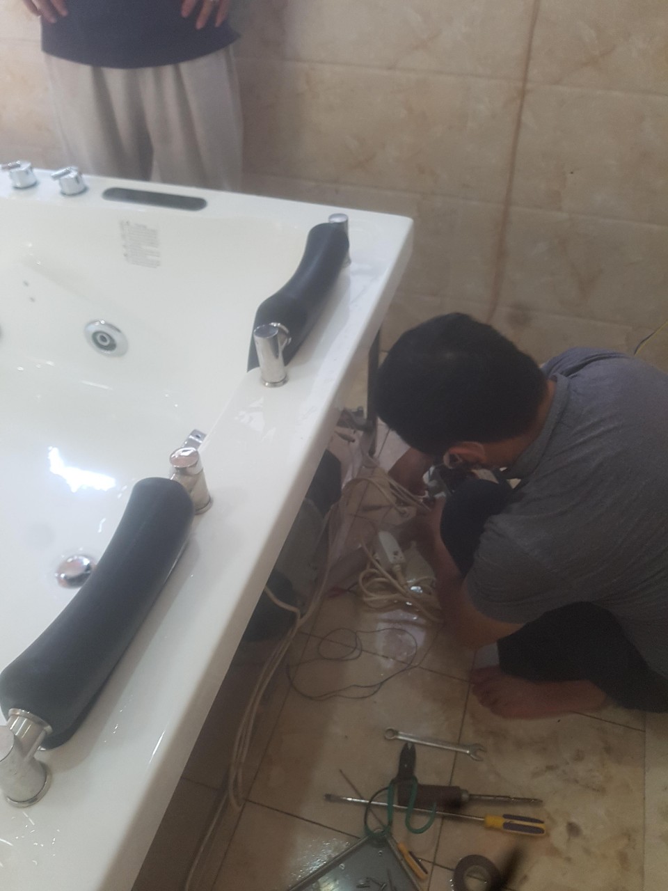 Hình ảnh thực tế nhân viên của trung tâm đang sửa chữa bồn tắm massage